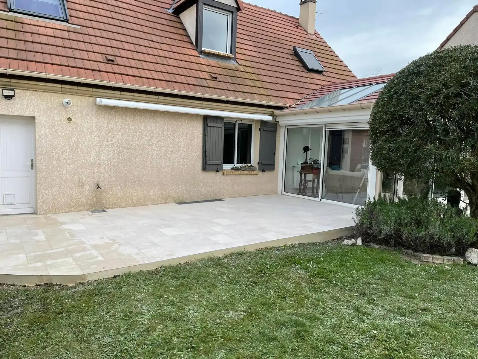 Terrasse en dalles devant une extension vitrée
