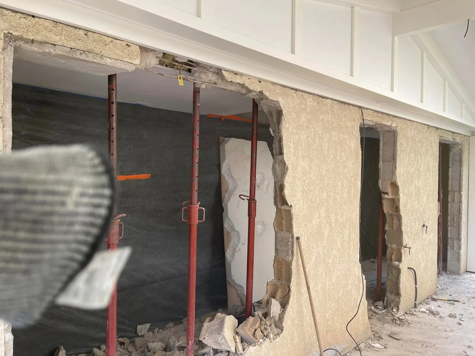 Le mur porteur découpé entre les étais, gravats au sol
