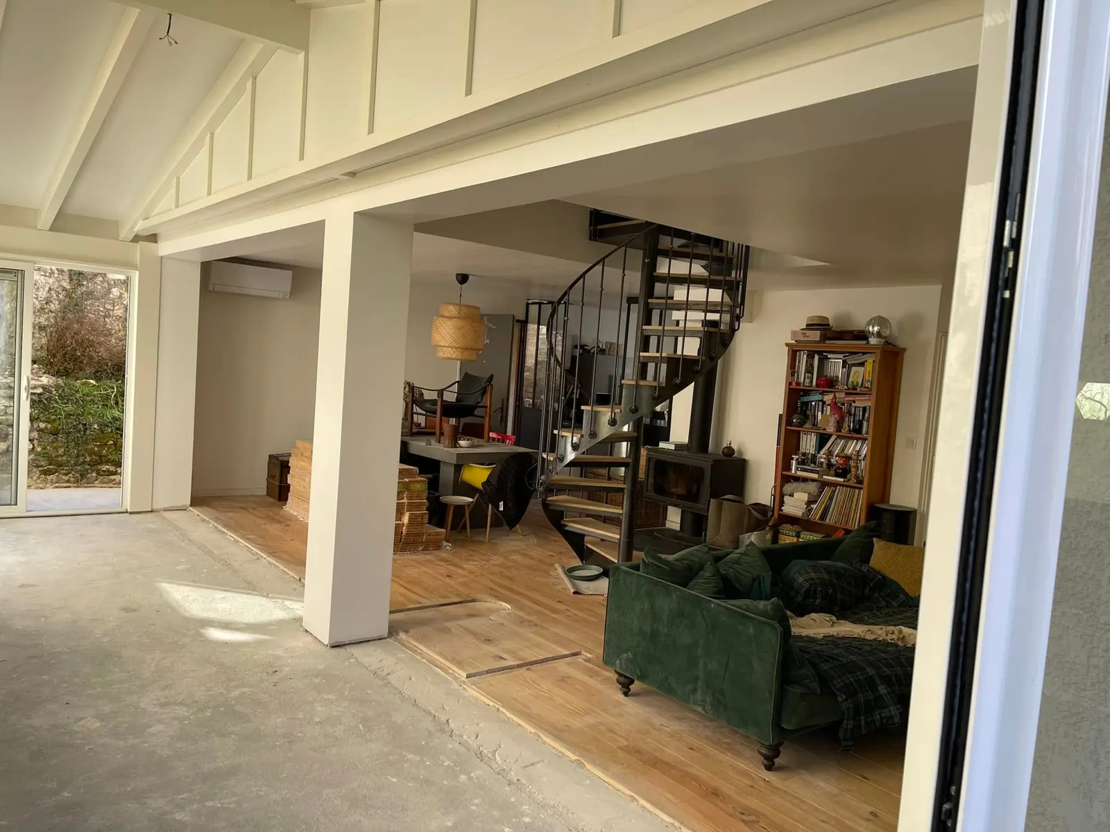 Salon et véranda réunis après l’ouverture du mur porteur, sous le nouveau plafond