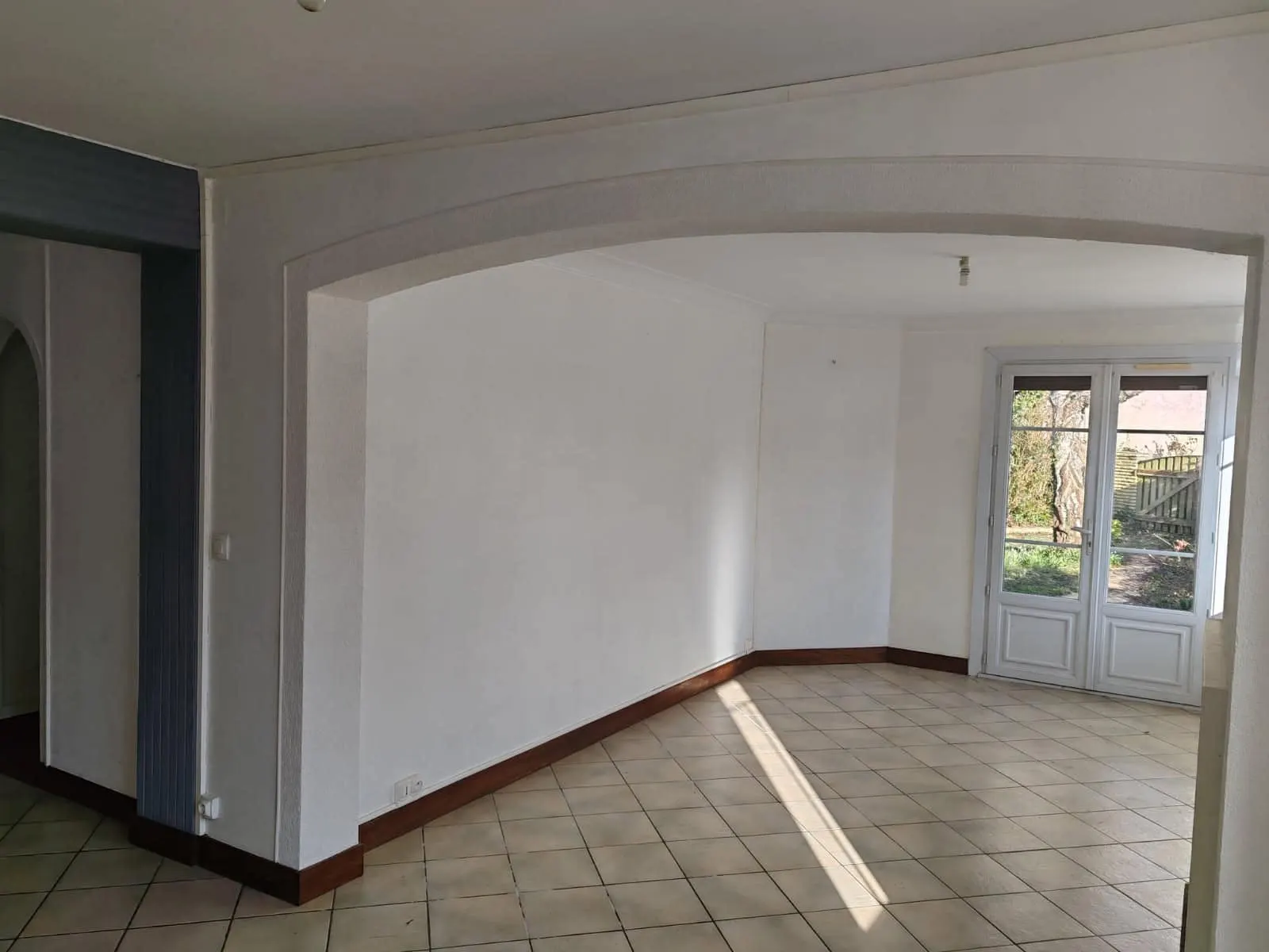 Pièce rénovée, sol carrelé et arche