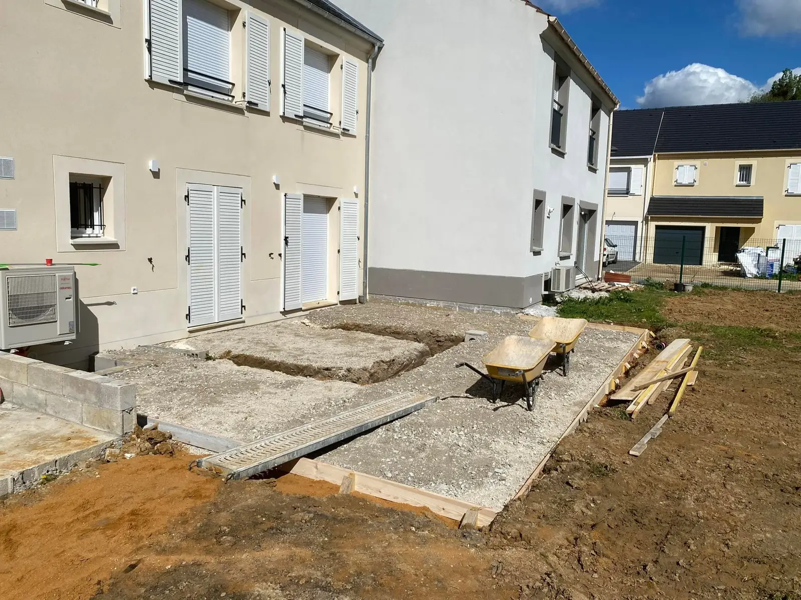 Terrain préparé et coffrage posé devant la maison, avant la coulée