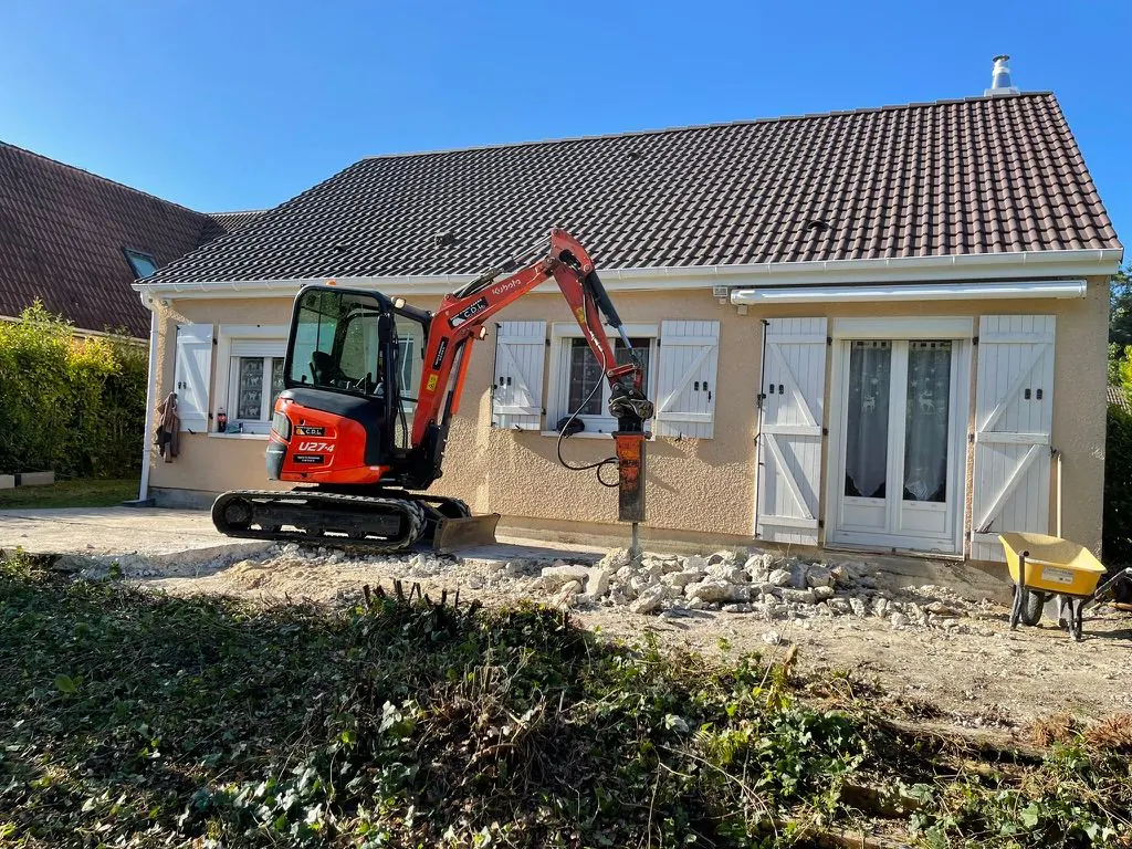 Mini-pelle de l’équipe en terrassement devant une maison
