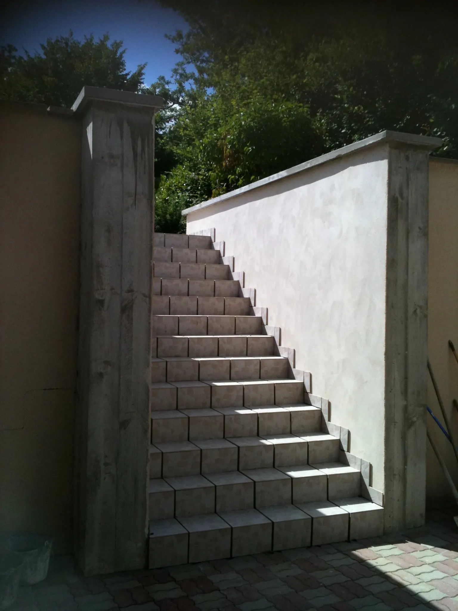 Escalier extérieur carrelé le long d’un mur enduit